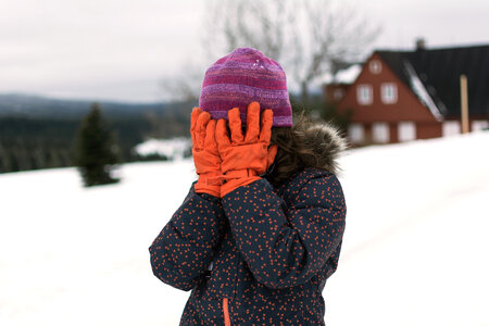 Little girl covers her face in winter photo