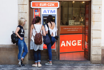 Three young women and ATM