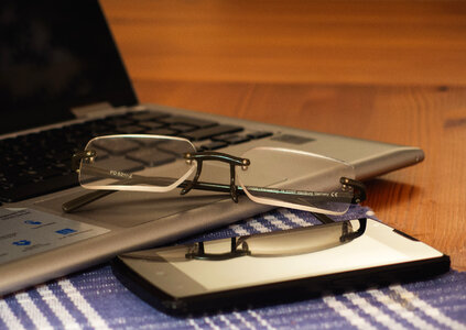 Glasses, Laptop And Phone On The Office Desk photo