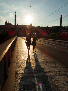 Two tourists – girls walking on the Prague bridge
