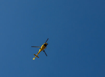 Yellow helicopter against the blue sky