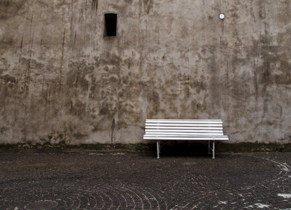Empty white bench in front of the old wall photo