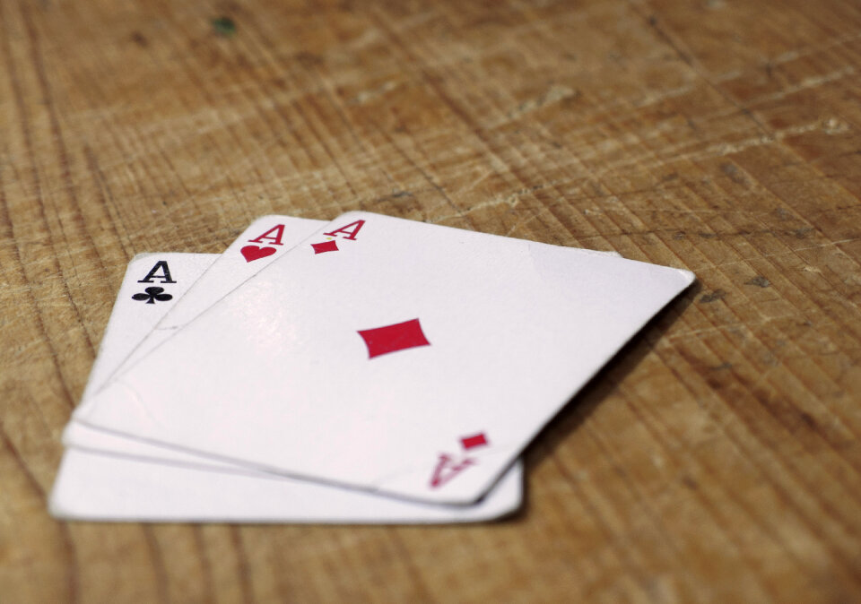 Three Aces Cards On Wooden Table