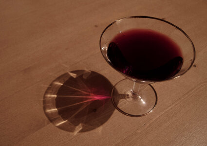 Glass of red wine on a wooden table photo