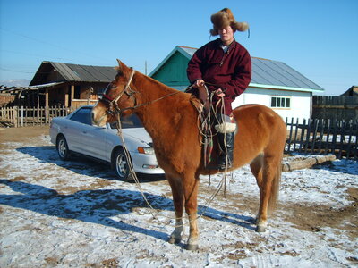 Mongolian man riding a horse photo