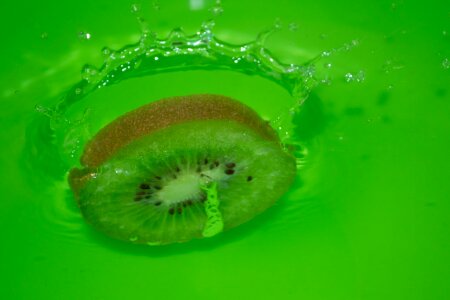 Slice of kiwi hitting water photo