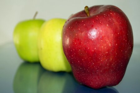 Green and red apples reflection on glass