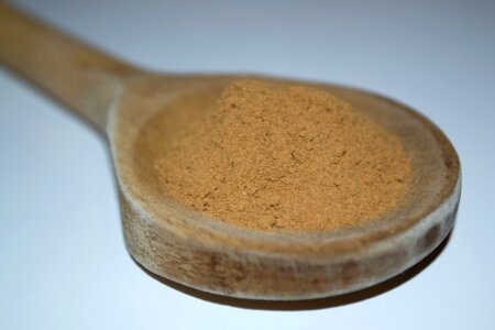 Cinnamon powder in wooden spoon photo