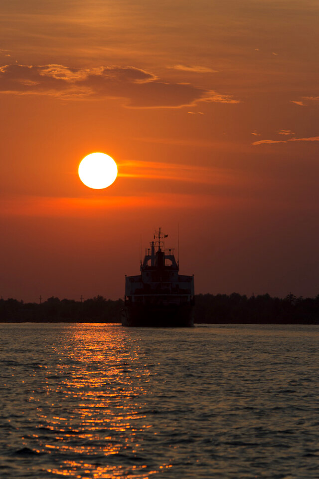 Ship sailing into sunset