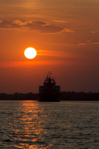 Ship sailing into sunset photo