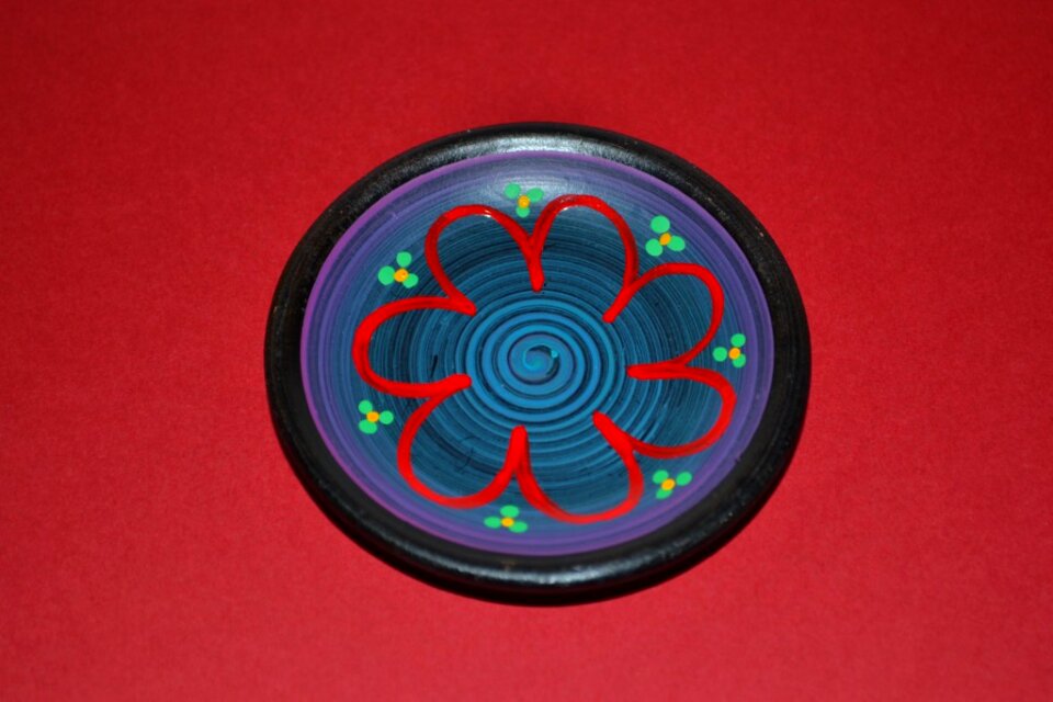 Miniature ceramic plate isolated on red
