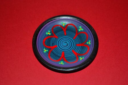 Miniature ceramic plate isolated on red