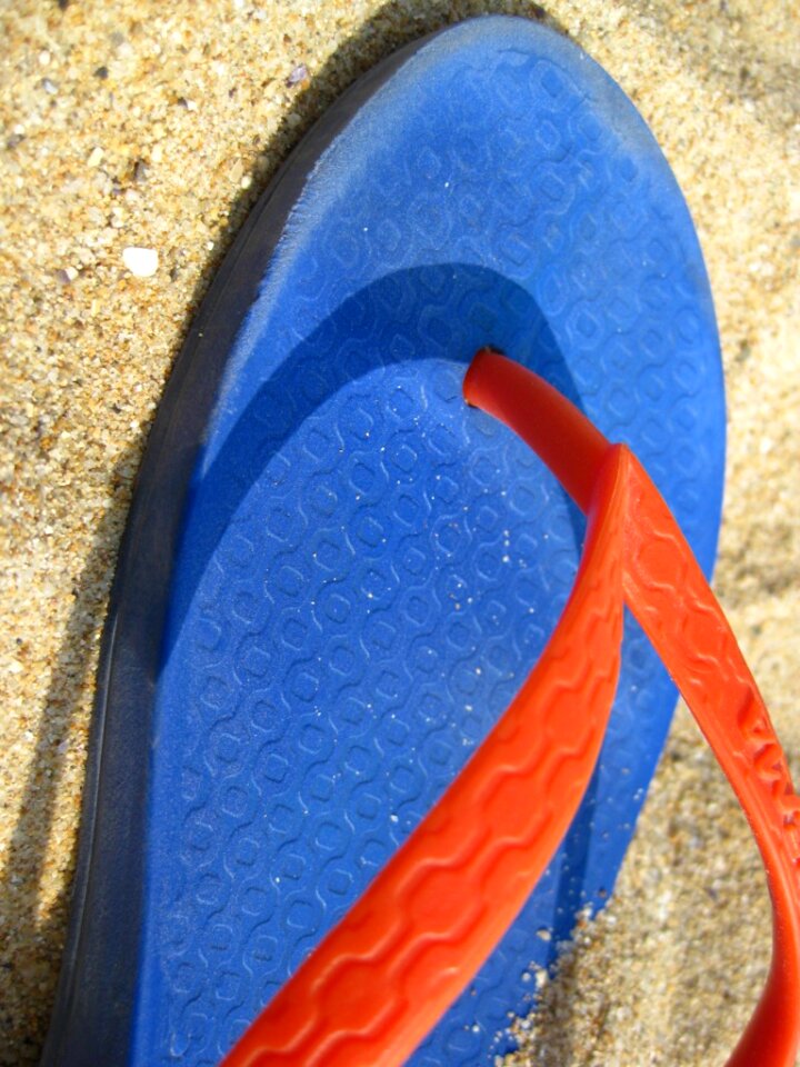 Colorful flip flop on sand