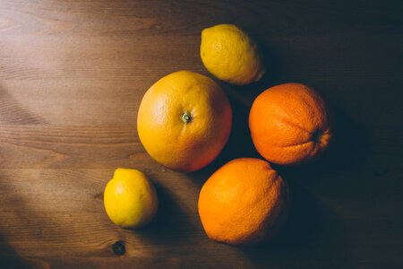 A grapefruit, oranges and lemons on a wooden table photo