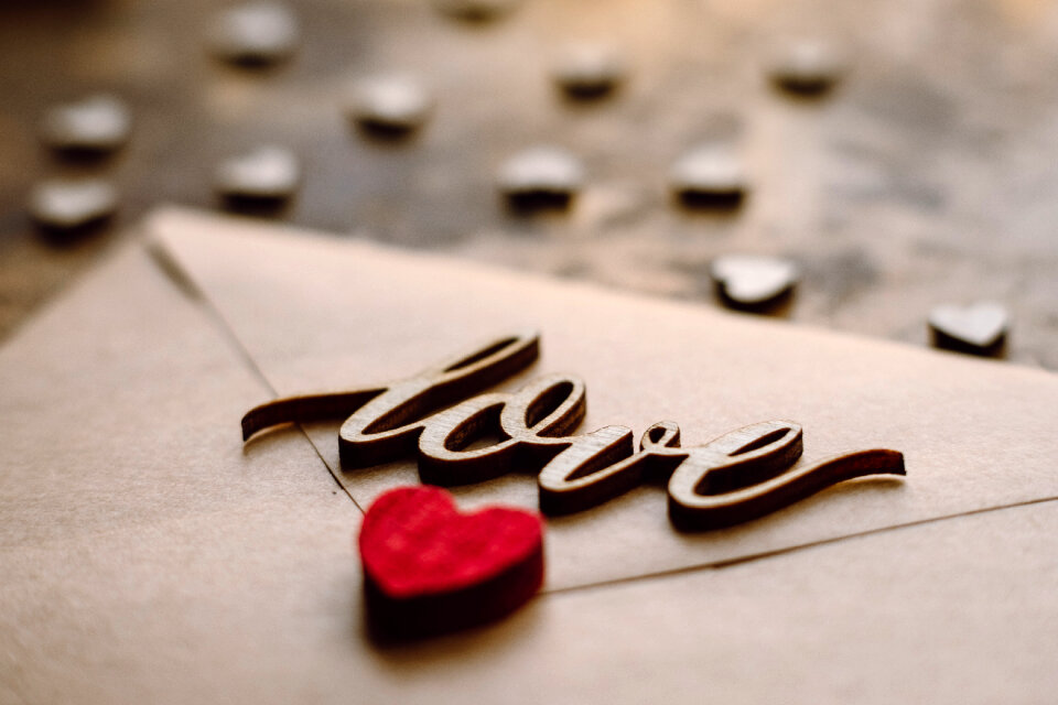 Wooden word love on a beige envelope