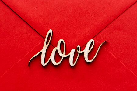 Wooden word love on a red envelope photo