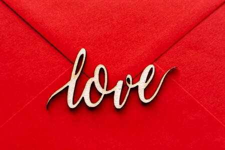 Wooden word love on a red envelope