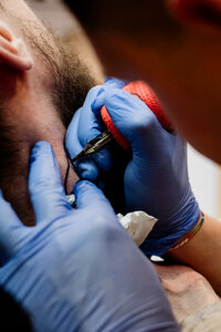 Tattoo artist at work closeup 3