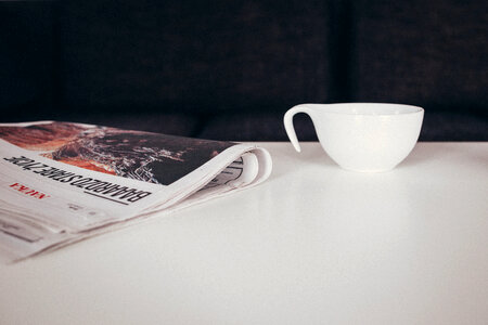 Cup of coffee and a newspaper on the table photo