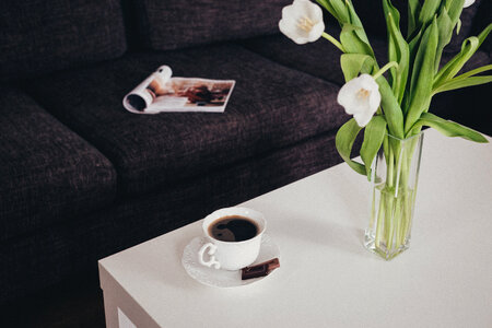 Cup of coffee and tulips on the table photo