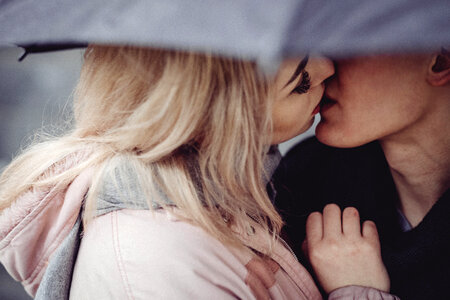 Couple kissing under an umbrella photo