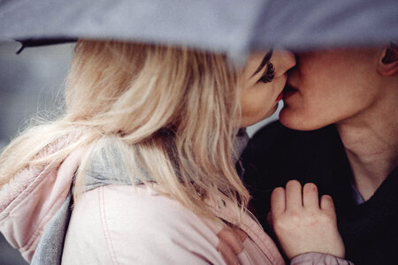 Couple kissing under an umbrella