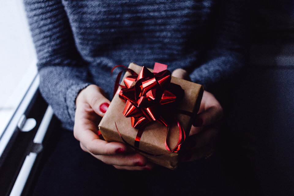 A female holding a wrapped gift