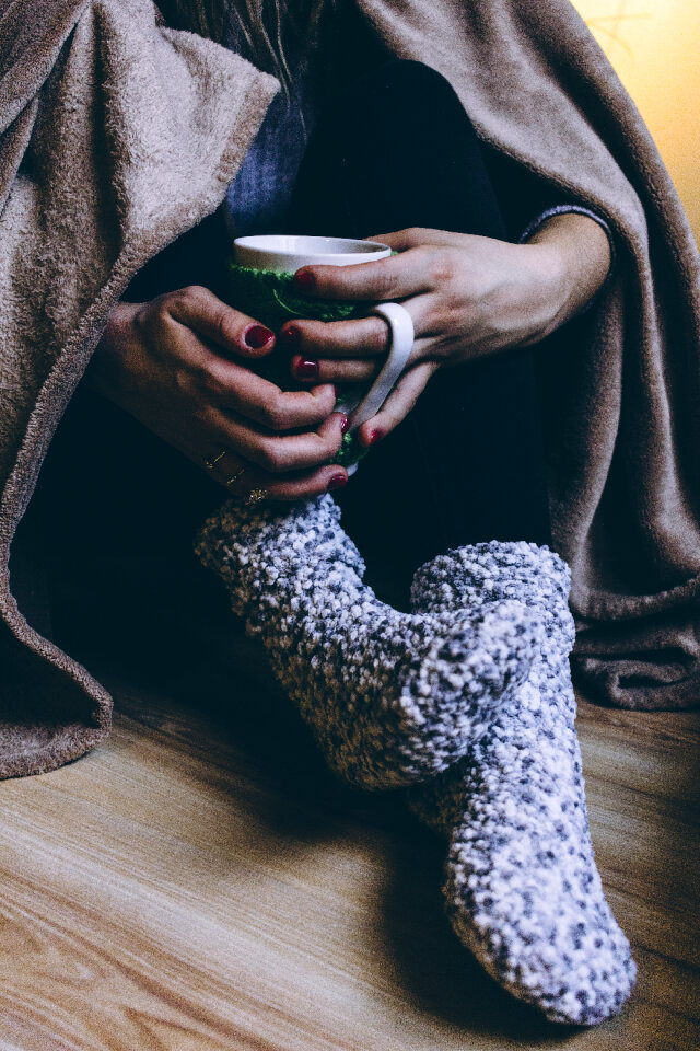 A female in warm socks holding a mug
