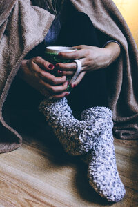 A female in warm socks holding a mug photo