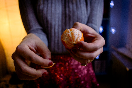 A female peeling a mandarin photo