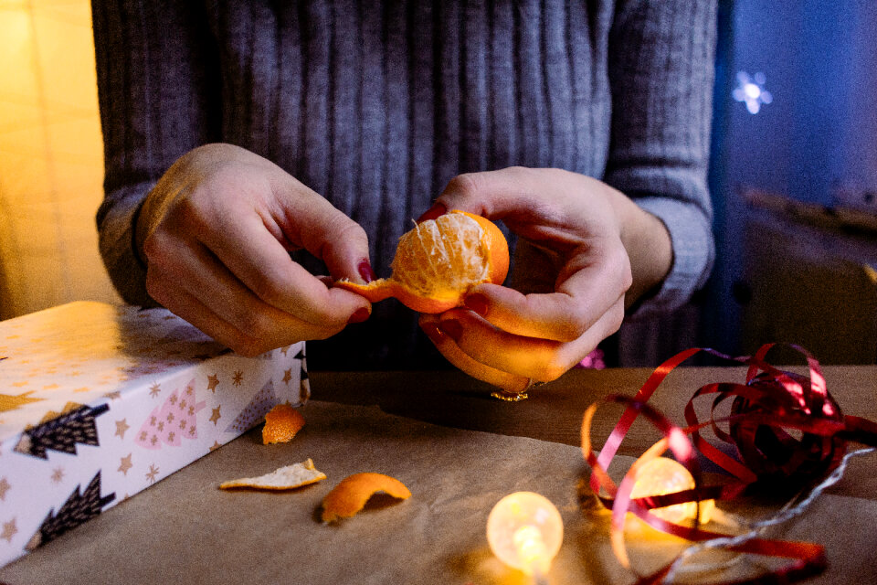 A female peeling a mandarin in a festive setting