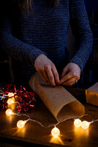 A female wrapping a gift photo
