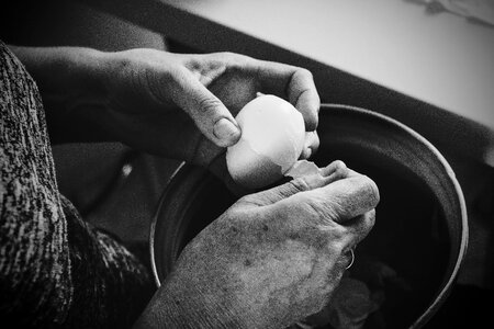 Old woman peeling an egg photo