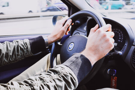 Male hands on a car steering wheel photo