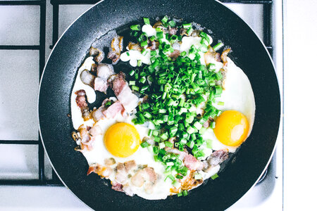 Eggs, bacon and chive on the frying pan photo