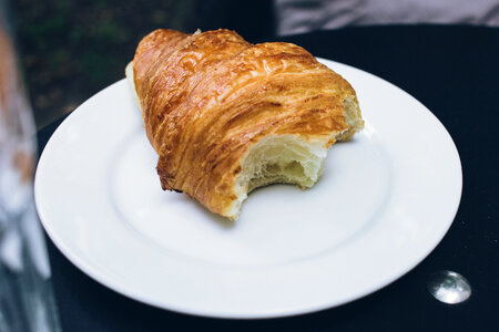 Bitten butter croissant on a plate photo