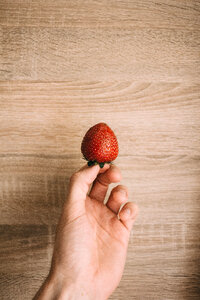 Strawberry in a male hand 2 photo