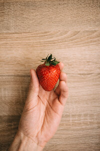 Strawberry in a male hand