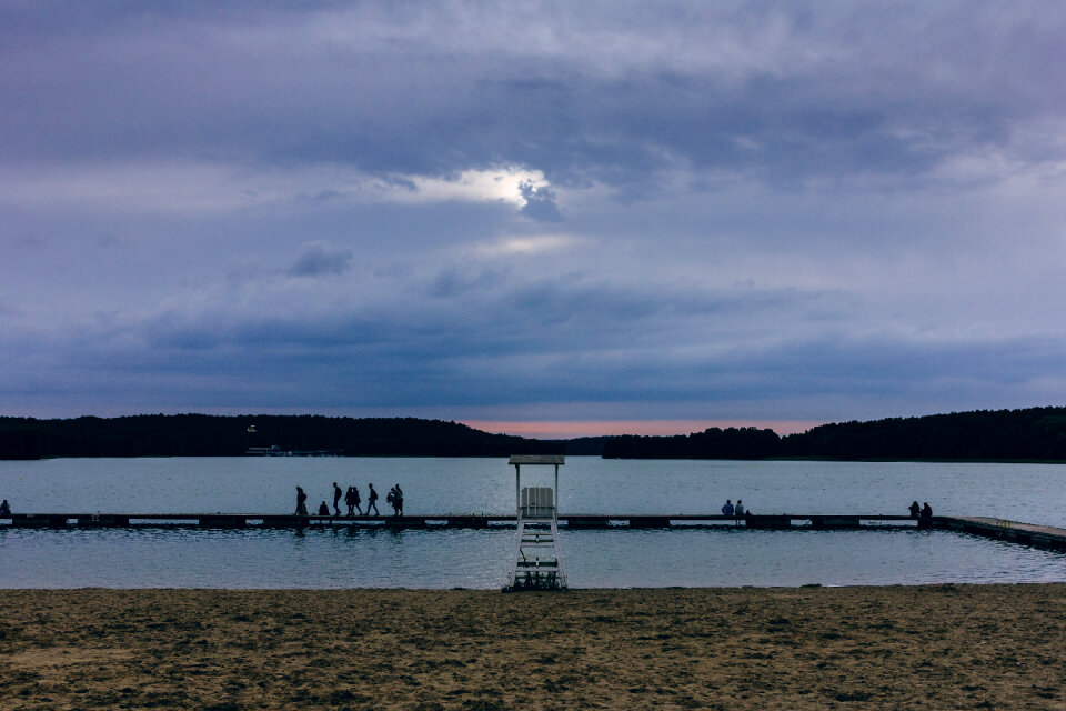 People standing on the pier at dusk