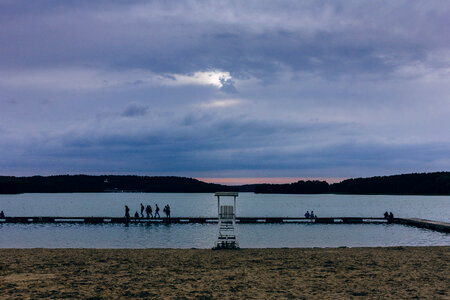 People standing on the pier at dusk
