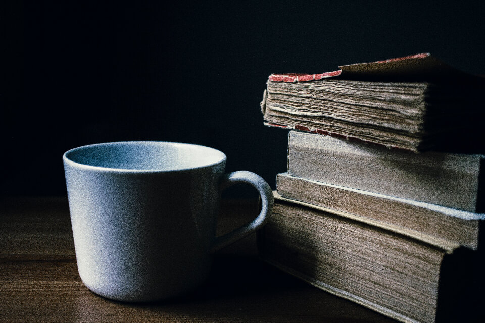 Tea mug and a pile of books