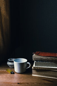 Tea mug, a lighter and a pile of books