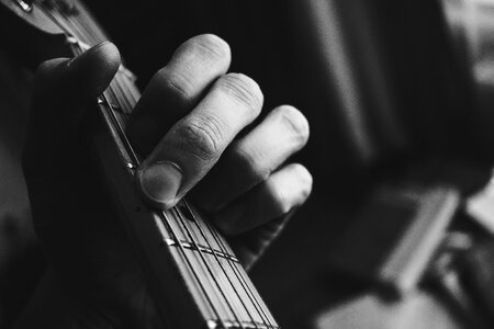 Guitarist hand playing guitar in black and white