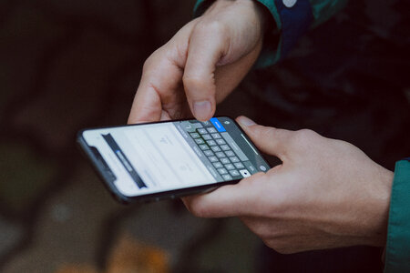 Male holding an iPhone X 2 photo