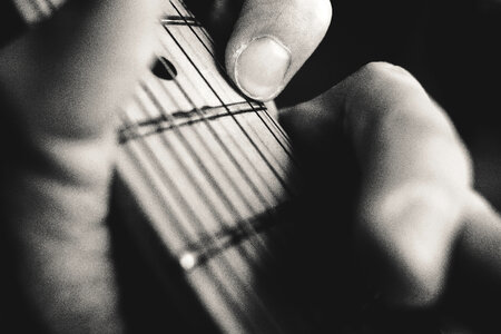 Guitarist hand playing guitar closeup photo