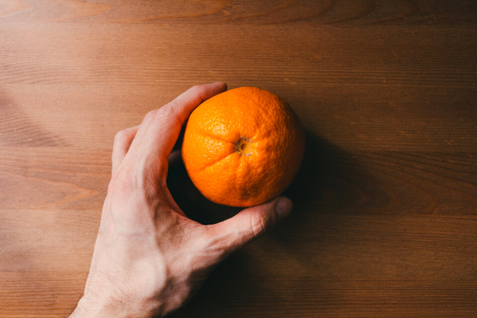Orange in a male hand