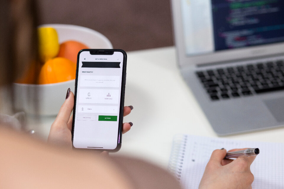 A female holding an iPhone X and taking notes 2
