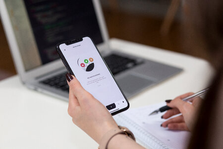 A female holding an iPhone X and taking notes 3