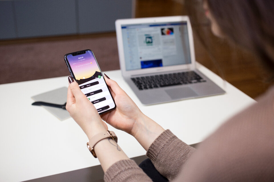 A female holding an iPhone X