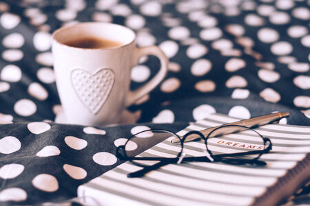 Coffee mug, notebook and glasses photo